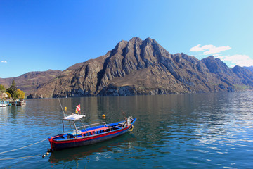 iseo lake - boat and mountain, view from port - obrazy, fototapety, plakaty