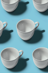 Pattern. Cup concept. Group of white cups on blue background. Creative style.