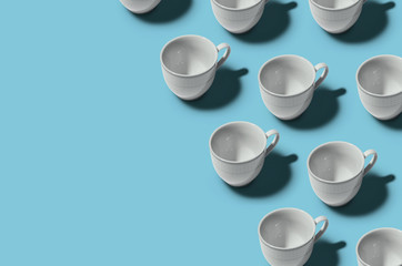 Pattern. Cup concept. Group of white cups on blue background. Creative style.