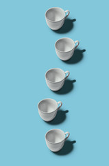 Cup concept. White cups on blue background.  Creative style.