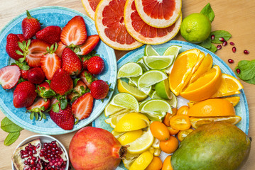 Variation of beautiful ripe fruit on a kitchen table, orange, lemon, lime, grapefruit, strawberry