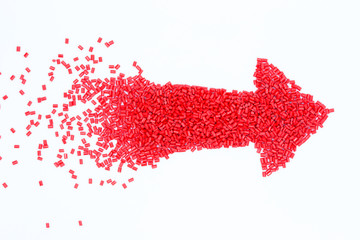 Red arrow design of plastic polymer granules isolated on white background