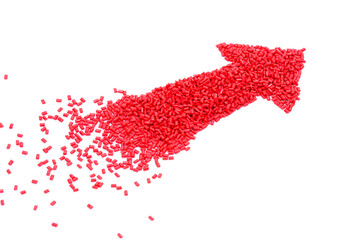 Red arrow design of plastic polymer granules isolated on white background