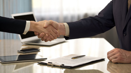 Male concluding business deal, shaking hands with partner, company partnership