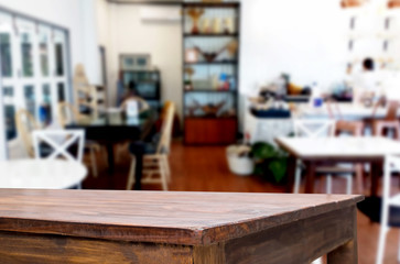Selected focus empty brown wooden table and Coffee shop or restaurant blur background with bokeh image. for your photomontage or product display.
