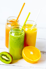 Fresh detox juices in glass bottles on white background