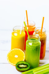 Fresh detox juices in glass bottles on white background