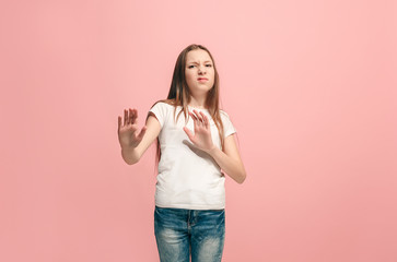 Doubtful pensive teen girl rejecting something against pink background