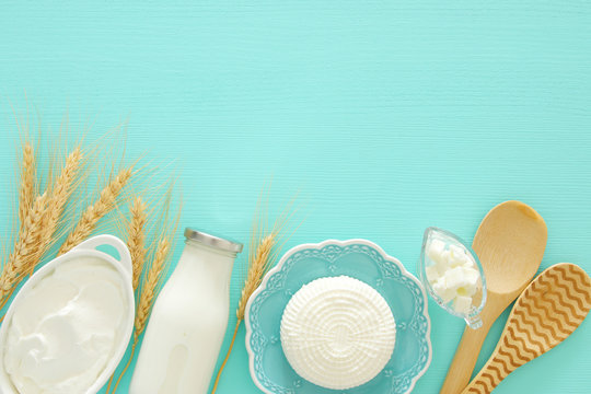 Top view image of dairy products over mint wooden background. Symbols of jewish holiday - Shavuot.