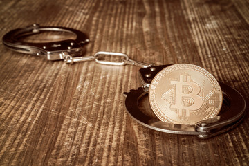 Golden bitcoin and handcuffs