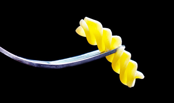 Pasta on a fork, isolated against a black background