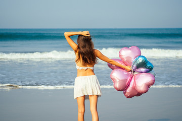 young and beautiful girl holding an air helium ball on the sea. concept of holiday and vacation....