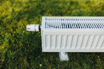 radiator on green lawn, ecological heating concept