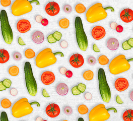 Vegetable mix on white wooden isolated background. Fresh yellow pepper, chopped tomatoes, onion, round cucumber slice, carrot, radish. The concept of a healthy lifestyle. Vegetarian food.