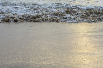 Sea waves hit the beach shore.