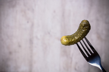 Cucumber on the fork in the gray background
