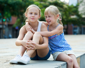 Two smiling little girls embracing