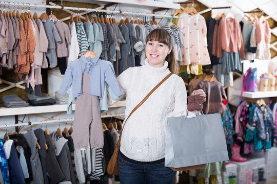 Adult pregnant mother choosing clothes for baby