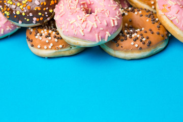 Colorful round donuts on blue background.