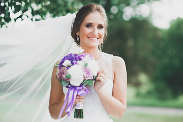 Portrait of stunning bride with long hair posing with great bouquet