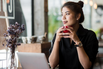 Happy Asian woman drinking coffee and work at café, lifestyle concept.