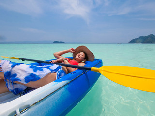 Asian woman on the kayak boat in Andaman blue sea and blue sky background location in Phuket island Thailand