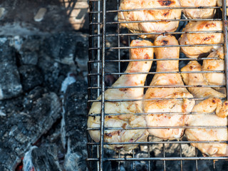 Fresh grilled chicken baked over coals in an open space