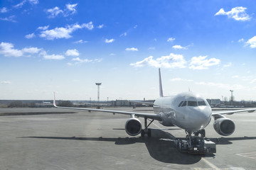 airplane is dragged by car airport and docking in international airport with sunny blue sky background