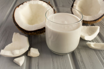 Obraz na płótnie Canvas Coconut milk in the glass on the grey wooden background