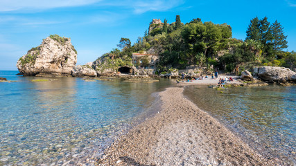“Isola Bella” Island of Taormina, Sicily. Beautiful  pebbles beach with cliffs and crystal clear water. Hidden paradise island, covered with vegetation, on the coastline of Taormina, Sicily.
