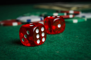 Dice on the poker table against the background of poker chips
