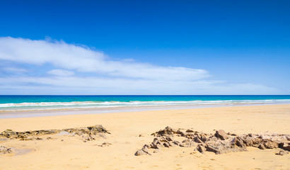 Coastal rocks on sandy beach of Porto Santo