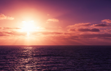 Obraz premium Seascape with sun in dramatic cloudy sky