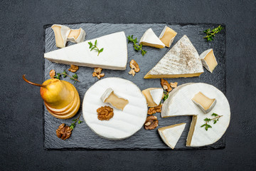 Camembert cheese and pear on stone board
