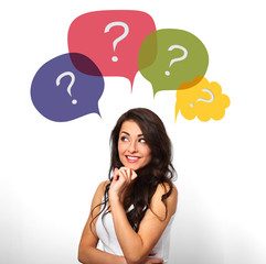 Thinking casual smiling woman with many colorful questions in bubbles above the head on white background
