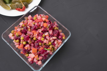 Traditional Russian salad vinaigrette on a gray background and copy space.