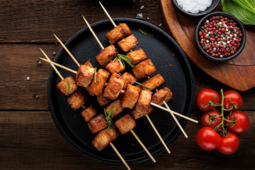 Grilled meat skewers, shish kebab on dark wooden background, top view