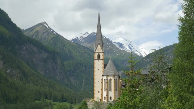 Panning view of the chapel in Heiligenblut am Grossglockner in Carinthia, Austria, with Grossglockner in the background.