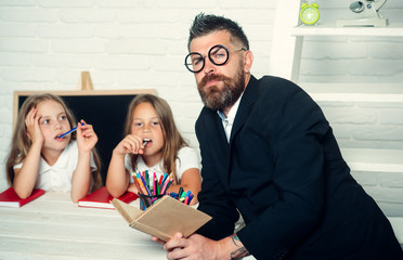 Education in knowledge day. Literature lesson and reading grammar book. Teacher man read story to...