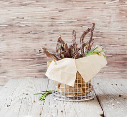 jerked meat, cow, deer, wild beast or biltong in kraft paper bowls on a rustic table, selective...