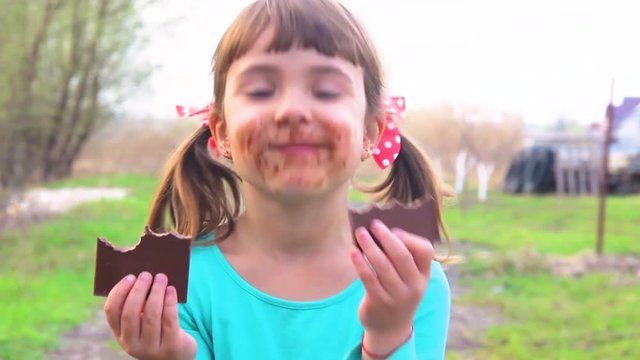 A sweet-toothed child eats chocolate. 