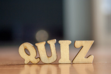 The word 'quiz' made of wooden letters. wood inscription on table