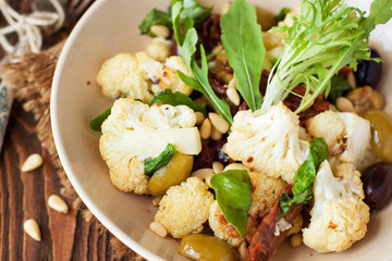 Roasted cauliflower salad with olives, tomatoes, nuts and basil