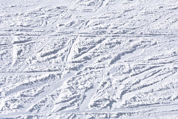 Ski slope with traces of skis on a sunny day.
Background, texture.
