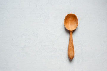 A wooden spoon handmade lies on a gray background.
