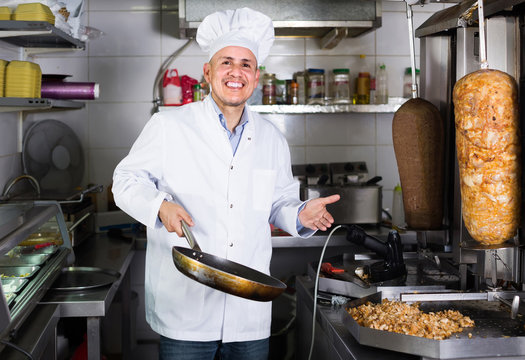 man cook making kebab dish on kitchen in fast food restaurant