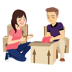 Young lovely couple packing things in box moving concept