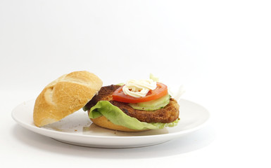 Wiener schnitzel in a bun with lettuce tomato and mayonnaise