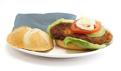 Wiener Schnitzel in einem Brötchen mit Salat Tomate und Mayonnaise