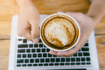 woman holding hot cup of coffee, view from the top